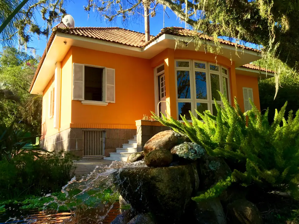 Casa histórica entre rochas, cascata e vegetação nativa
