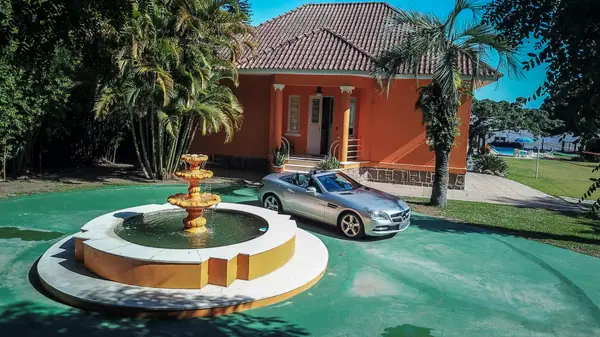 Fachada da Casa Theodor com chafariz e automóvel clássico