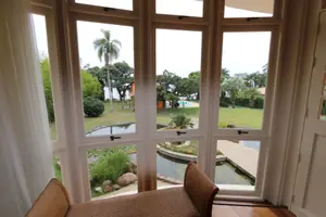 Janela envidraçada com vista para o gramado e o lago