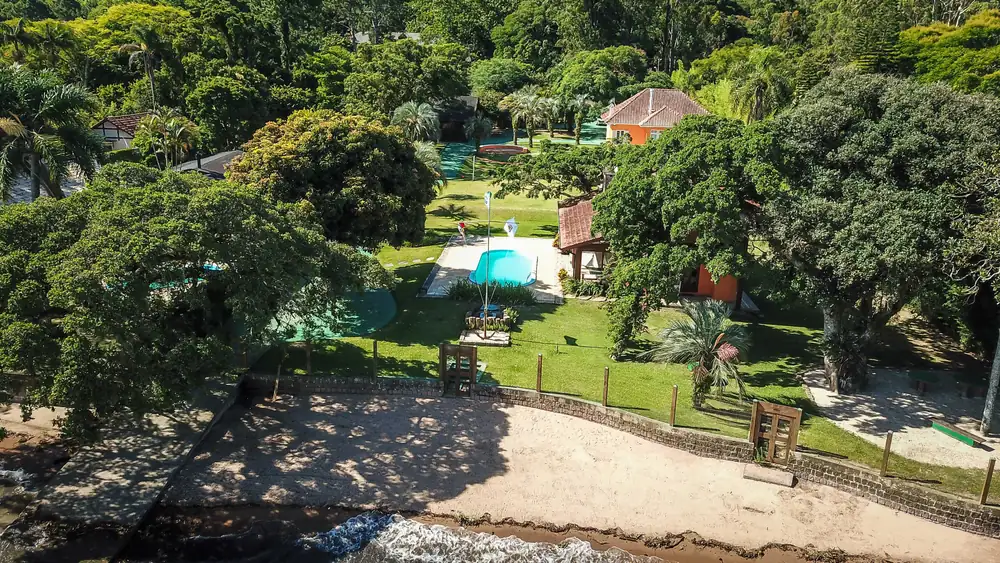 Vista aérea do terreno, com as edificações entre a vegetação
